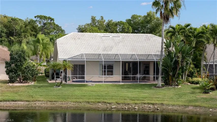 Back of house with a lakeview, a water view, and a tile roof