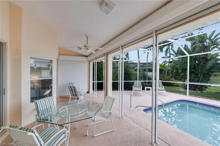 Swimming pool featuring a sunroom, a lanai, and a patio area