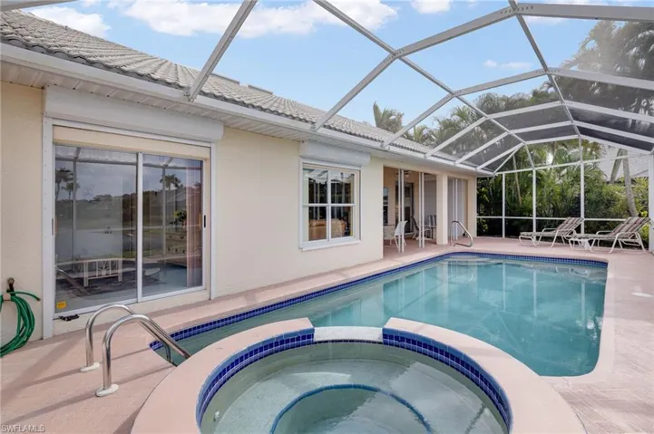 View of swimming pool featuring a sunroom, a patio, a pool with connected hot tub, and a lanai