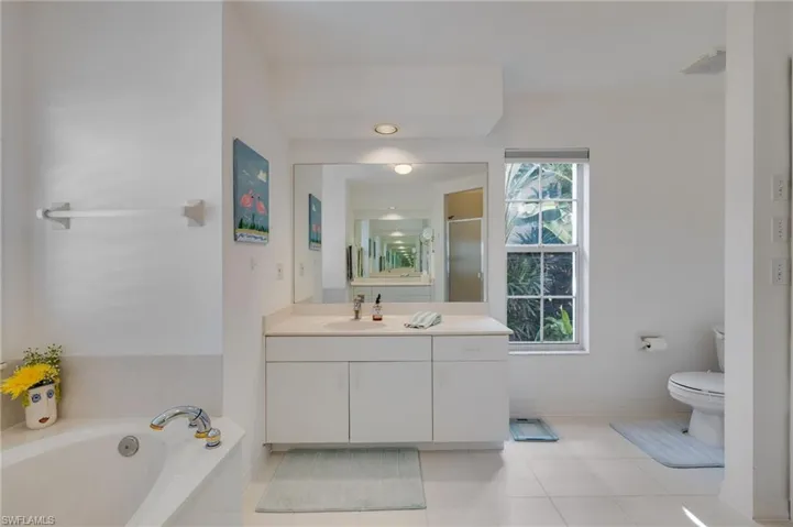Bathroom with vanity, a garden tub, a shower stall, and light tile patterned floors