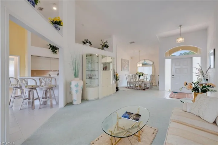 Carpeted living area with a high ceiling and tile patterned floors