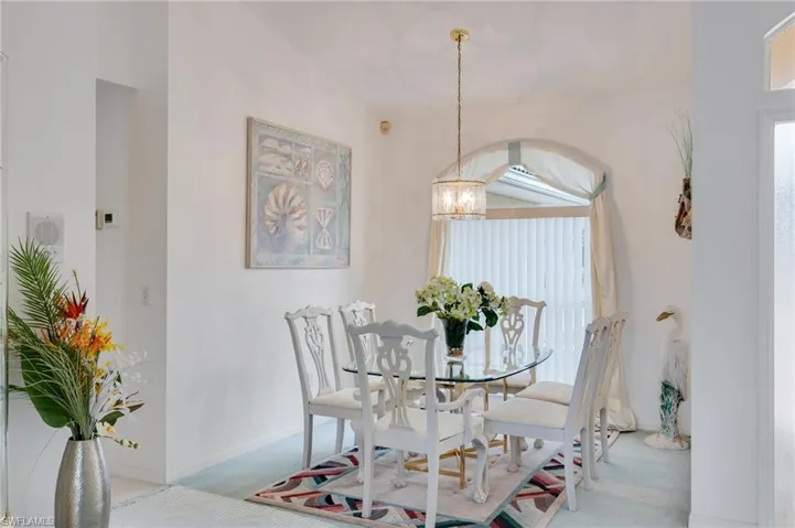 Dining room featuring light carpet and a chandelier