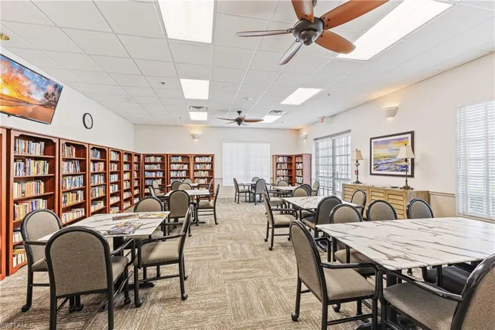Carpeted dining area with ceiling fan and a paneled ceiling
