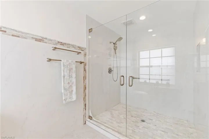 Updated Master Bathroom featuring walk in shower and tile walls