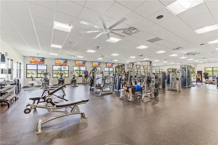 Exercise room with ceiling fan and a paneled ceiling