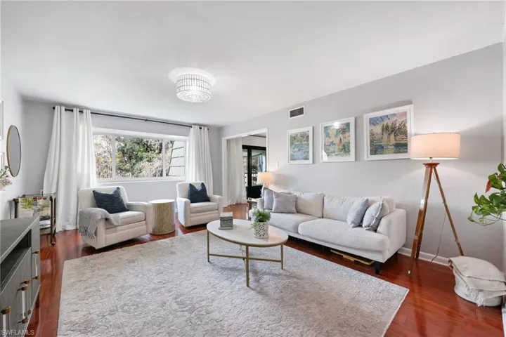 Living room featuring dark wood finished floors, visible vents, and baseboards