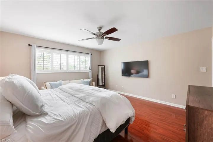 Bedroom featuring a ceiling fan, baseboards, and dark wood-type flooring