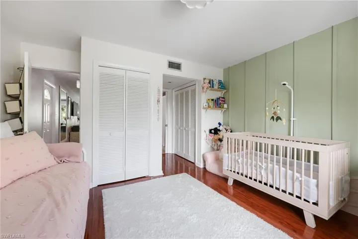 Bedroom featuring dark wood-style flooring and visible vents