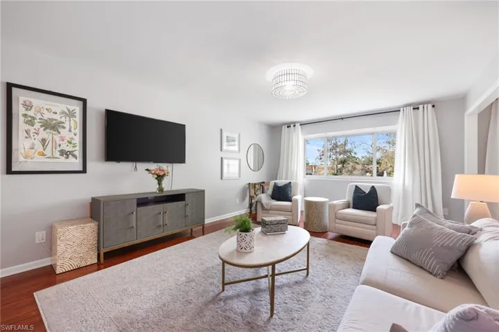 Living area featuring dark wood-style floors and baseboards