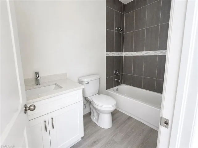 Bathroom featuring a white vanity with an integrated sink, polished chrome faucet, and light-toned countertop