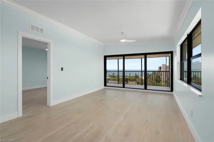 This room features light-colored flooring, light blue walls, and a ceiling fan