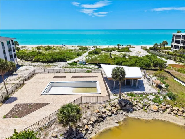This property features a direct view of the beach and ocean, with a swimming pool area, and a covered outdoor structure