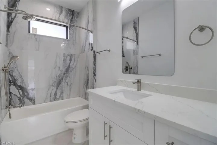 Full bathroom featuring toilet, vanity, and tiled shower / bath