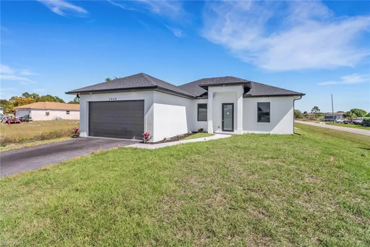 View of front of house with a front yard and a garage