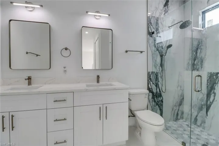 Bathroom with toilet, vanity, and walk in shower