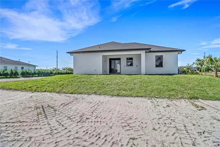 Back of property with a lawn