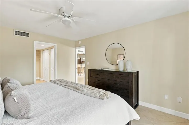 Neutral-toned room featuring a white ceiling fan and light-colored tile flooring