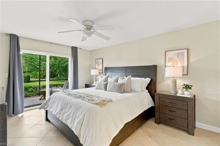 Neutral interior featuring tile flooring, ceiling fan, and sliding glass doors with exterior access to a screened patio