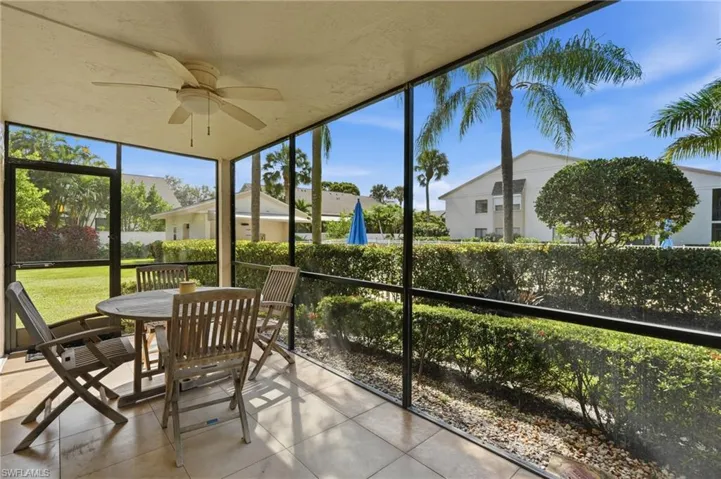 Screened patio featuring tile flooring, a ceiling fan, and black metal framing