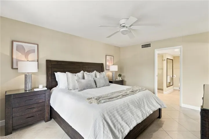 Neutral-toned interior space featuring light-colored tile flooring and a ceiling-mounted light fixture with fan blades