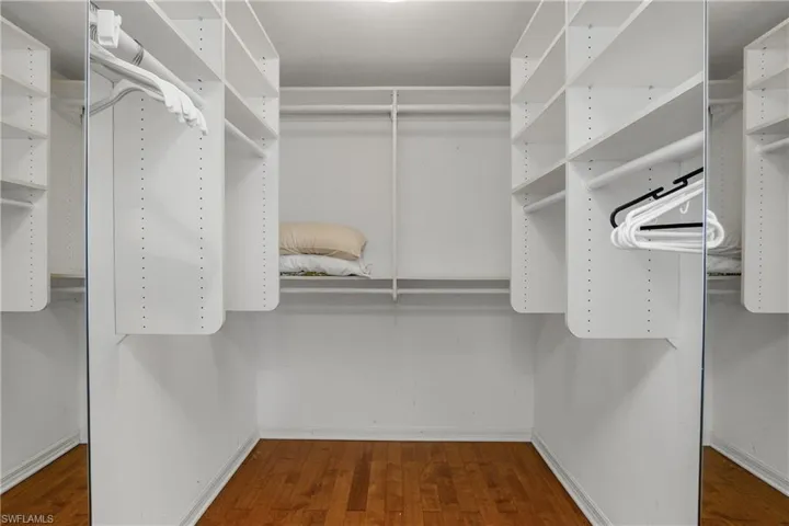 Hers walk-in closet. His closet opposite w/built-in cabinetry