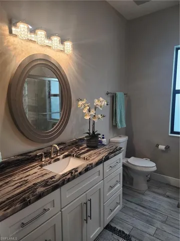 Full bath featuring a tub shower, vanity, and wood tile finish floors