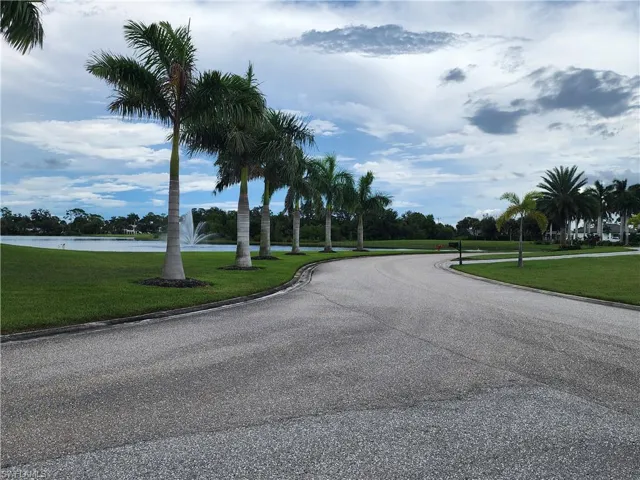 View of asphalt street featuring curbs and a water view with fountain