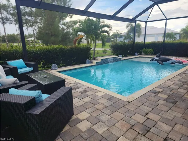 Outdoor pool with picture window screen enclosure, an outdoor hangout area, and spacious lanai