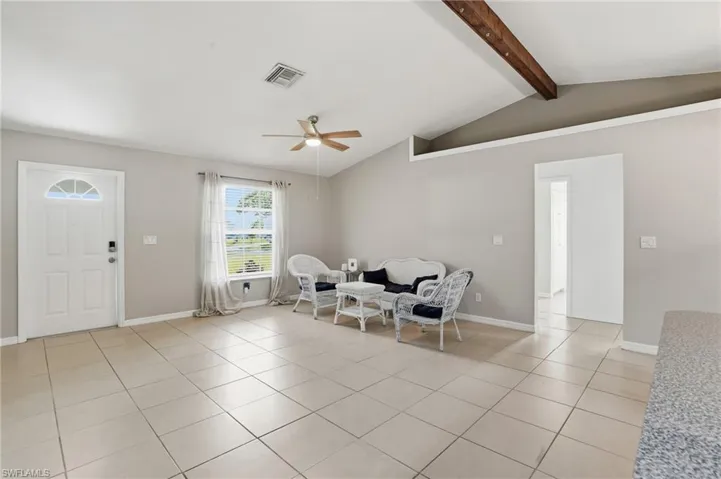 Living area featuring light tile patterned floors and a ceiling fan