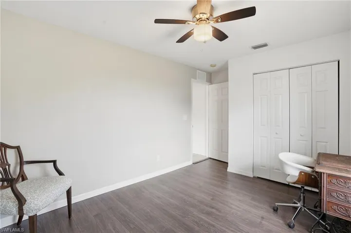Bedroom with dark wood-style floors and a ceiling fan