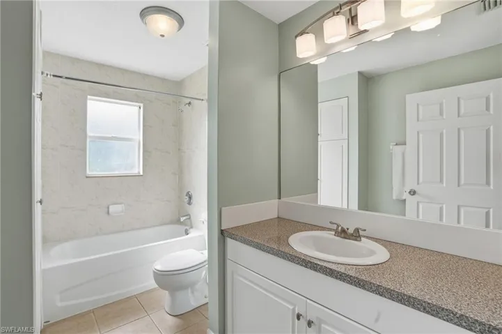 Bathroom with vanity,  shower combination, and light tile patterned flooring