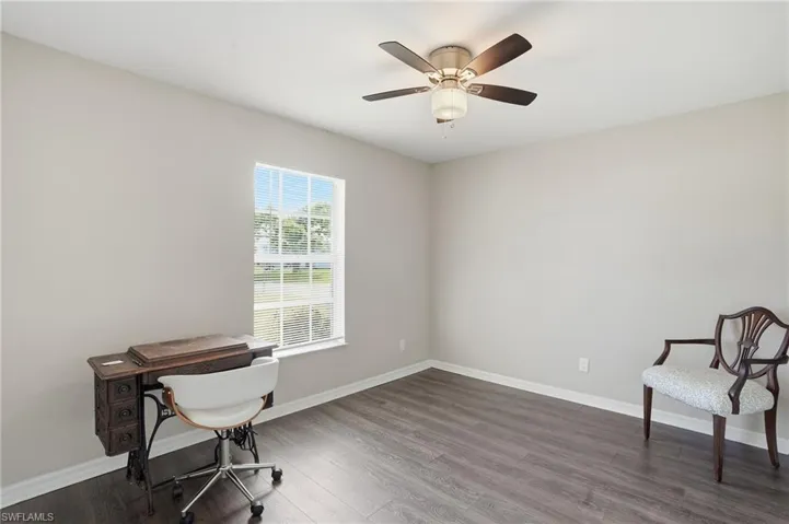 Bedroom with dark wood-style floors and baseboards