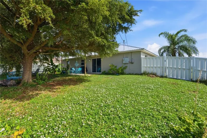 Rear view of house with stucco siding, a patio, and a metal roof