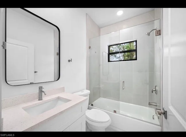 Master Bathroom with combined bath / shower with glass door and vanity