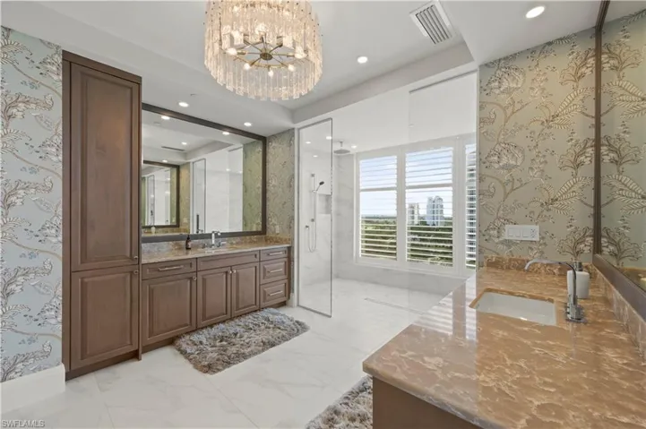 Primary bathroom with two separate vanities, a spacious walk in shower and two private water closets.