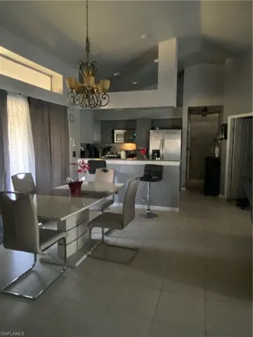 Dining room with suspended lighting and light tile patterned floors