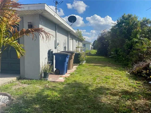 View of side of home featuring a lawn and stucco siding