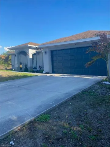 View of home's exterior featuring stucco siding, driveway, and a garage