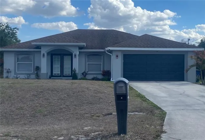 Single story home with a shingled roof, an attached garage, driveway, stucco siding, and french doors