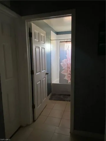 Corridor with light tile patterned floors and baseboards