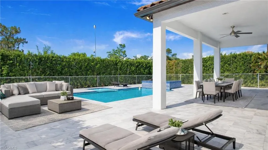 Virtually Staged  View of swimming pool featuring a fenced backyard, an outdoor living / dining area, and patio surround