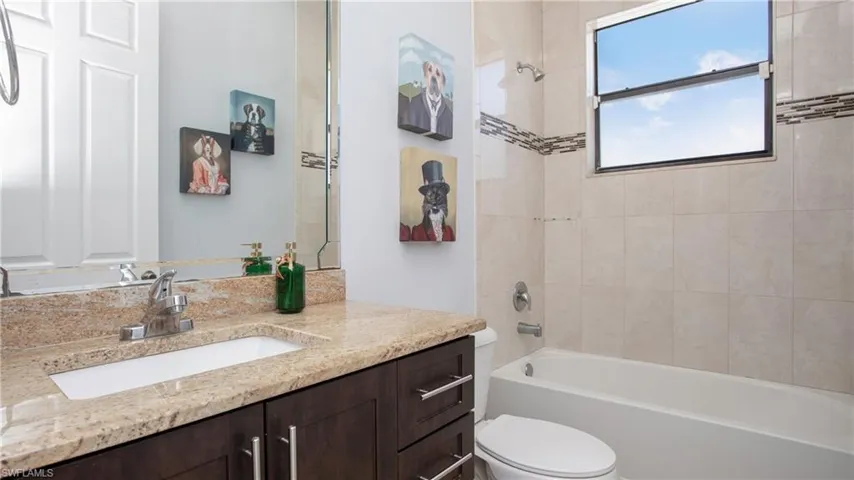Full bathroom with toilet, shower / bath combination, and vanity