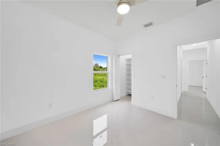 Unfurnished bedroom featuring tile patterned flooring, ceiling fan, and a closet