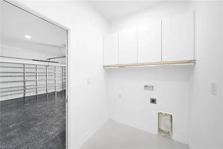Laundry room featuring hookup for a washing machine, electric dryer hookup, and cabinets