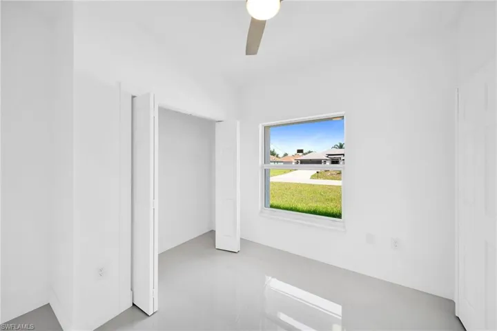 Unfurnished bedroom with light tile patterned floors and ceiling fan