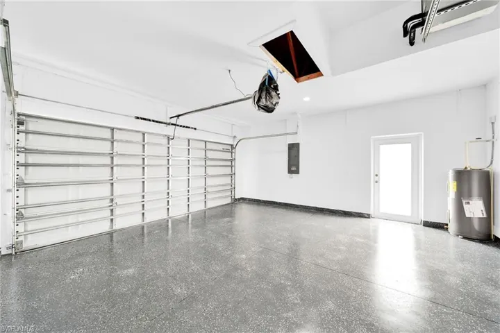 Garage featuring electric water heater and electric panel
