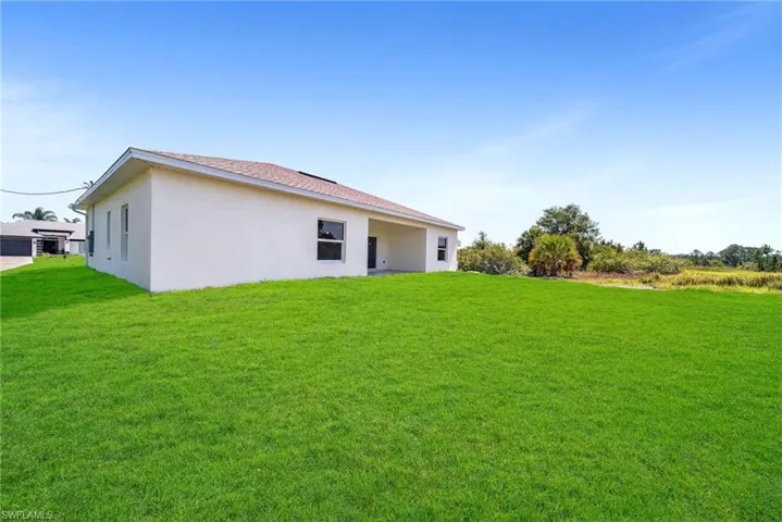 Back of property featuring a yard