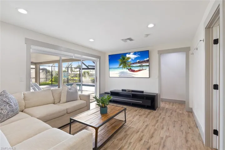Living room with light wood-style flooring and recessed lighting