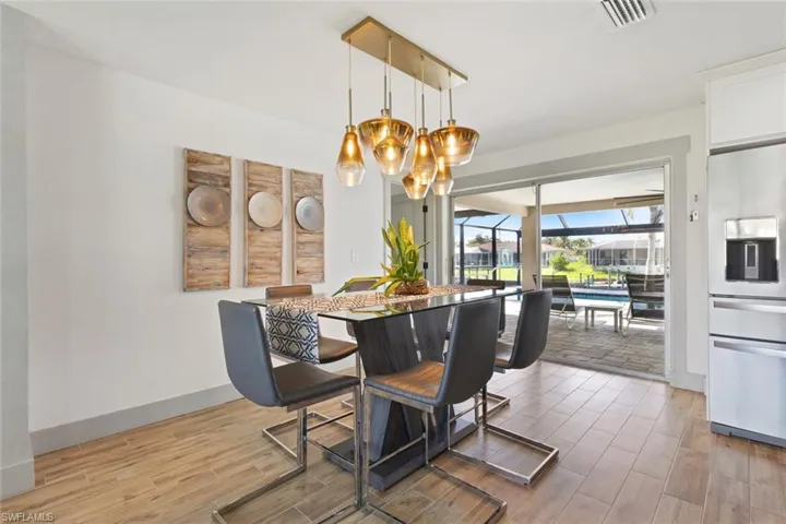 Dining space with a sunroom and light wood-style floors