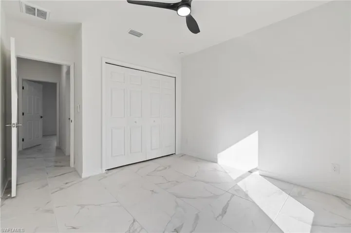 Unfurnished bedroom featuring ceiling fan and a closet